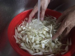 Trộn đều củ kiệu với bột mì sau đó rửa sạch với nhiều nước cho củ kiệu trắng sáng hơn.