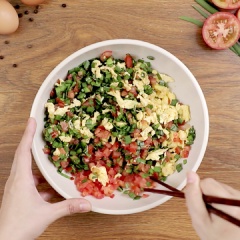 Trộn nhân: Cho hẹ, cà chua, trứng quậy vào một tô. Nêm thêm ½ thìa cà phê tiêu, 1 thìa cà phê muối, 1 muỗng nước tương, trộn đều cho các nguyên liệu hòa quyện.