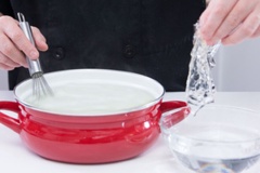 Đặt nồi lên bếp, cho 220ml sữa tươi không đường vào. Thả 2 lá gelatin vào sữa ngâm khoảng 5 phút để lá gelatine mềm ra.