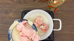 Bắc lên bếp một chiếc nồi lớn, đun nóng 2 muỗng canh dầu ăn sau đó thêm 15gr hành tím thái lát vào phi thơm. Tiếp theo cho 600gr giò heo vào xào lên cho săn và giò heo dậy mùi thơm. Đổ vào nồi 1.2 lít nước hầm xương heo, thêm 30gr củ hành tím nướng và 10gr gốc ngò rí để nước dùng có mùi thơm. Mở lửa lớn đun sôi rồi hớt bọt, sau đó hạ lửa nhỏ, hầm giò heo 45 phút cho thật mềm.