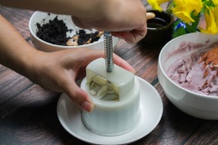 Cho một lớp vỏ bánh vào khuôn nhấn bánh trung thu, dùng muỗng tán nhẹ ra thành khuôn (tạo thành 1 cái lỗ). Cho nhân bánh vào rồi dàn đều. Tiếp tục thêm vỏ bánh lấp kín rồi nhẹ nhàng ấn bánh tạo hình.