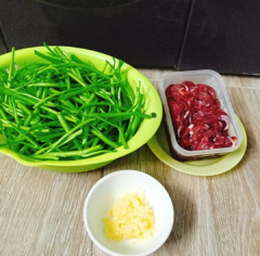 Ướp thịt bò với 1 muỗng cà phê dầu hào, 1 muỗng cà phê nước tương, nửa muỗng cà phê đường. Cho tỏi vào phi thơm với 1 ít dầu ăn.