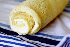 Nhân phô mai: Cho phô mai Mascarpone, đường bột, mật ong, kem heavy cream vào trộn đều ở tốc độ trung bình khoảng 1 phút cho đến khi kết hợp mịn nhuyễn. Sau khi bánh đã nguội gỡ khăn ẩm ra, quết kem phô mai lên một lớp mỏng, cuộn tròn đều. Rây một lớp đường bột lên trên. Sau đó dùng dao cắt lại cho đều bánh.