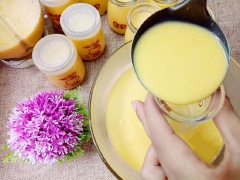 Tiếp đến đổ 2 hũ sữa chua cái vào hỗn hợp sữa bí đỏ và khuấy cho quyện đều. Sau đó rót chúng vào các hũ nhỏ thủy tinh, đậy kín nắp lại.