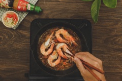 Xếp những con tôm và tôm chiên vào chảo, đun liu riu khoảng 20-30 phút cho tôm ngấm đều gia vị. Vớt tôm ra tô. Hòa tan bột bắp với nước rồi cho vào chảo nước sốt, khuấy đều cho sệt lại, tắt bếp.