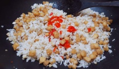 Mở lửa lên lại, rồi cho tiếp 1 muỗng canh dầu ăn vào chảo cơm cùng sả băm trộn cho đều, sau đó để tiếp ớt băm vào cũng trộn đều, tắt bếp.