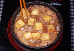 Sau khi chiên đậu xong thì cho 2 muỗng canh đường vào chảo để thắng đường lấy màu, để ở lửa cho cho tới khi đường chuyển sang màu vàng thì cho hành băm vào và phi thơm vàng. Sau đó cho thịt vào xào đều tay cho thịt chín lại và ra bớt mỡ. Cho tiếp 1/2 chén nước lọc vào kho cho thịt mềm và thấm. Khi thịt đã hơi thấm thấm thì cho đậu hũ vào kho cho tới khi nước cạn và chuyển sền sệt là được.