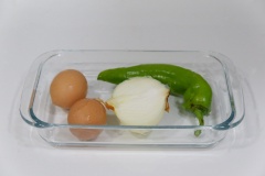 Đập 2 quả trứng gà cho ra chén, thêm 1/4 muỗng cà phê muối vào, dùng đũa đánh tan đều. Bỏ cuống và hạt ớt cắt đôi theo chiều ngang trái ớt rồi ớt sợi nhỏ. Bóc vỏ hành tây, thái sợi mỏng.