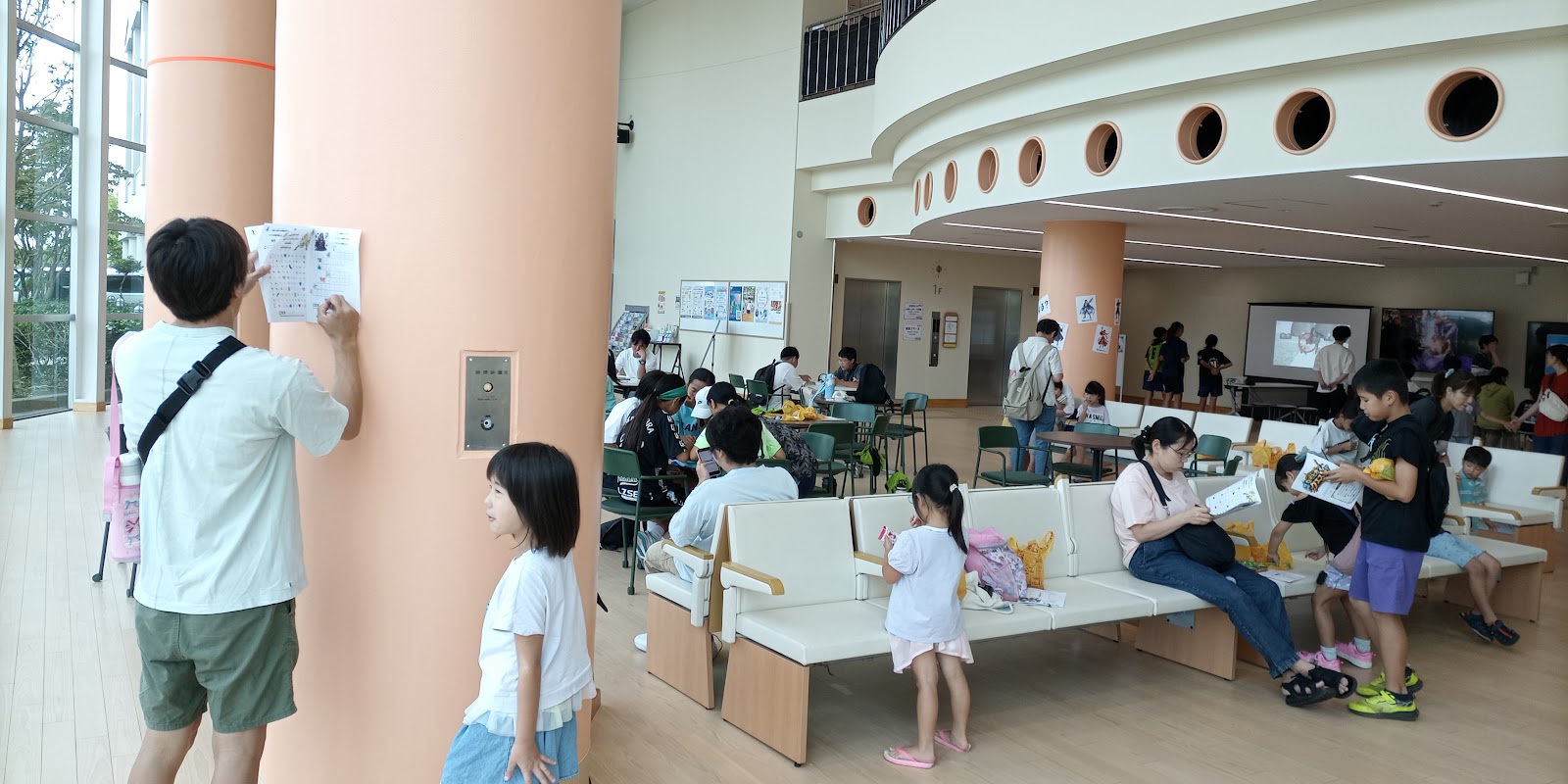 謎解きのヒントを探して会場を巡る家族の様子
