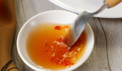 Cho tỏi băm, hành tím băm vào chén, rót hỗn hợp nước mắm vừa đun vào, khuấy đều lên là được.