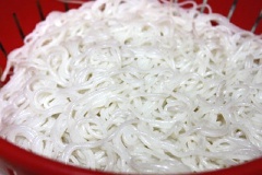 Bún chần qua nước sôi rồi đổ ra rổ cho ráo nước. Hành lá, ngò rí lặt sạch, cắt nhỏ. Xà lách rửa sạch, chanh bổ làm đôi, ớt rửa sạch.