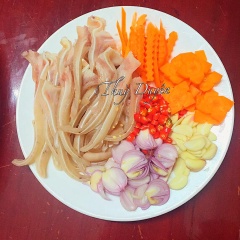 Sau đó dùng dao cắt miếng tai heo vừa ăn. Đồng thời cắt hành tím, ớt trái, tỏi, cà rốt.