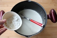 Đầu tiên, cho sữa tươi, kem whipping, 50gr đường trắng, 20gr bột bắp vào nồi, khuấy đều lên.