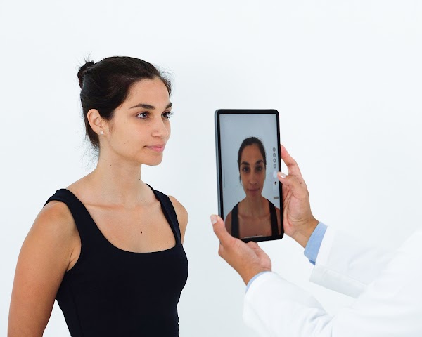 Le médecin prend une photo du profil avant du patient avec une tablette pour créer un modèle 3D avec Crisalix.