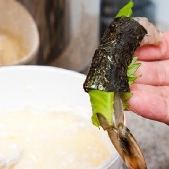Cho tôm vào chảo sôi ngập dầu, sau đó để tôm nguội, cuốn bên ngoài tôm 1 lớp lá tía tô và 1 lớp lá rong biển. Trong hình mình làm là cuốn lá trước rồi mới lăn bột chiên, nhưng như thế lá rất dễ bị rơi ra trong quá trình chiên tôm