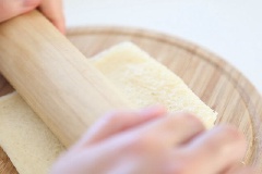 Dùng thìa nghiền nát khoai lang tím, sau đó trộn đều hỗn hợp. Bánh mì sandwich cắt bỏ phần diềm bánh, dùng cây cán bột ép chặt, làm như vậy bánh mì mỏng và mềm hơn, khi cuộn chuối vào sẽ dễ hơn.