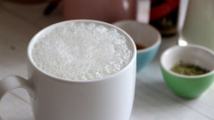 Gạn phần bọt qua một bên, bạn đổ sữa tươi nóng vào ly matcha đã pha sẵn. Sau đó hớt phần bọt cho lên trên ly matcha latte đến khi đầy ly nhé.