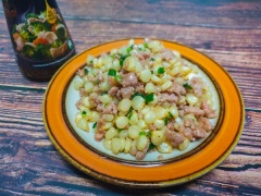 Cho bắp xào thịt ra dĩa rồi dùng kèm tương ớt, rất ngon và lạ miệng.