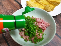 Trộn đều thịt với gia vị và hành lá cắt nhỏ.