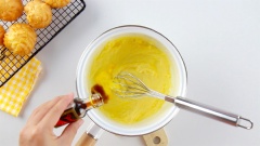 Nhanh tay thêm 10gr bơ lạt, 1/2 muỗng cà phê chiếc xuất vani, 1/2 muỗng cà phê muối vào nồi khi sốt còn nóng, khuấy đều tay để các nguyên liệu hoà quyện vào nhau tạo thành hỗn hợp bóng mịn.