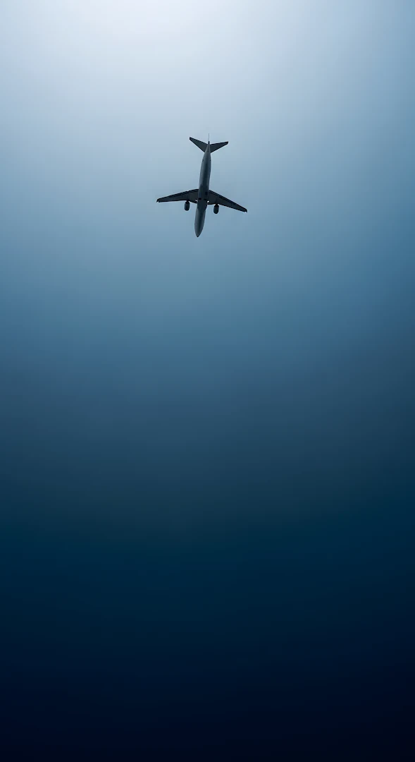 Commercial Jet Silhouette Against Deep Blue Gradient Sky