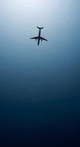 Commercial Jet Silhouette Against Deep Blue Gradient Sky
