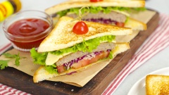 Khi dùng cắt đôi bánh sandwich khi còn nóng, ăn cùng tương ớt Maggi. Bánh sandwich có lớp vỏ giòn giòn, thơm mùi bơ, kẹp ở giữa là các loại rau cải tươi mát, phần thịt mềm mọng, chấm kèm với tương ớt Maggi càng làm tăng thêm hương vị sẽ khiến cho bạn càng ăn càng mê.