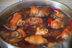 Cho thịt chân giò heo vào nồi, đảo đều. Sau đó thêm 2 muỗng canh nước tương, đảo nhanh tay cho thịt chân giò heo ngấm đều nước hàng sậm màu. Cho 500ml bia vào nồi giò heo và đun nhỏ lửa trong 1 giờ.
