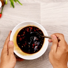 Pha 70ml nước tương, 40ml giấm đen, 80g đường cát, 4g ớt cắt lát và 50ml nước lọc, khuấy cho tan đường hoàn toàn. Bạn có thể điều chỉnh lại vị ngọt, chua, mặn, cay của nước chấm cho hợp với sở thích cá nhân của mình nhé.