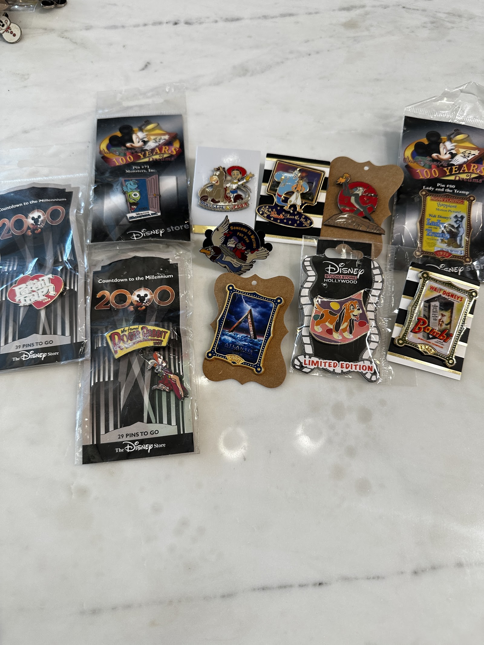 Eleven Disney commemorative pins on backing cards including 100 Years of Dreams, Countdown to the Millennium, DSSH Limited Edition Copper, Genie, Simba and Rafiki, and Bambi filmstrip