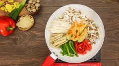 Đun nóng 1 muỗng canh dầu ăn, cho 20gr hành boa rô vào phi thơm. Lần lượt cho các loại nấm rau củ vào chảo gồm: 200gr nấm mỡ, 150gr nấm linh chi nâu, 50gr ớt chuông xanh đỏ, 100gr củ hủ dừa, 50gr tàu hủ ky và 100gr bông bí. Dùng sạn đảo đều các nguyên liệu.