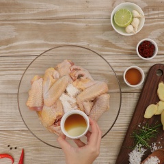 Nêm vào1 muỗng cà phê muối, 1 muỗng cà phê tiêu, 1/2 muỗng canh tỏi băm, 1 muỗng canh nước mắm, 2 muỗng canh nước nghệ tươi, 1 muỗng cà phê dầu mè, trộn đều rồi ướp gà 15 phút cho thấm gia vị.