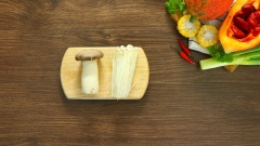 Gấc bỏ vỏ, hạt, lấy 100gr thịt gấc cho vào tô, thêm 2 muỗng canh rượu trắng, khuấy đều và dầm nhuyễn cho gấc lên màu đẹp. Cắt sợi 100gr nấm đùi gà, cắt đôi và bỏ gốc 100gr nấm kim châm.