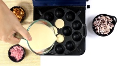 Bật lò nướng takoyaki lên, dùng giấy thấm dầu thoa dầu đều khắp khuôn. Đổ hỗn hợp bột lên cỡ nửa khuôn, cho bột tenkasu đã chiên giòn lên trên. Sau đó lần lượt cho bạch tuộc, hành lá và gừng ngâm chua vào.
