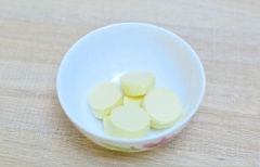 Bóc bỏ lớp vỏ bên ngoài, để phô mai vào bát riêng. Lót sẵn một lớp giấy nướng vào khay nướng bánh. Lấy khối bột bánh ra ngoài, các bạn hãy làm theo hướng dẫn ghi trên bao bì bên ngoài. Dùng gậy cán bột, cán mỏng khối bột để làm vỏ bánh.
