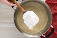 Trong một chiếc bát khác, dùng máy đánh trứng để đánh bông lòng trắng trứng. Đánh lòng trắng trứng đến khi nó mịn như kem, mất khoảng 10 - 15 phút. Từ từ cho hỗn hợp lòng trắng trứng vào sữa nóng, khuấy cho đến khi tất cả các thành phần hòa quyện vào nhau.