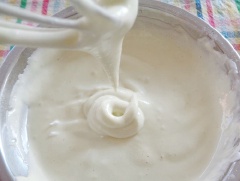 Lòng trắng trứng gà cho 30gr đường trắng, nước cốt dừa vào, dùng máy đánh trứng, đánh đều lên.