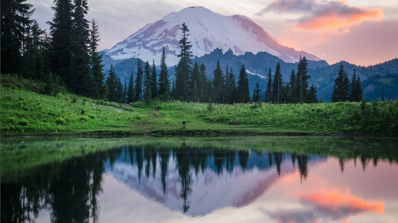 Mount Rainier summit and glaciers mirrored perfectly in the calm water of Reflection Lake at sunrise
