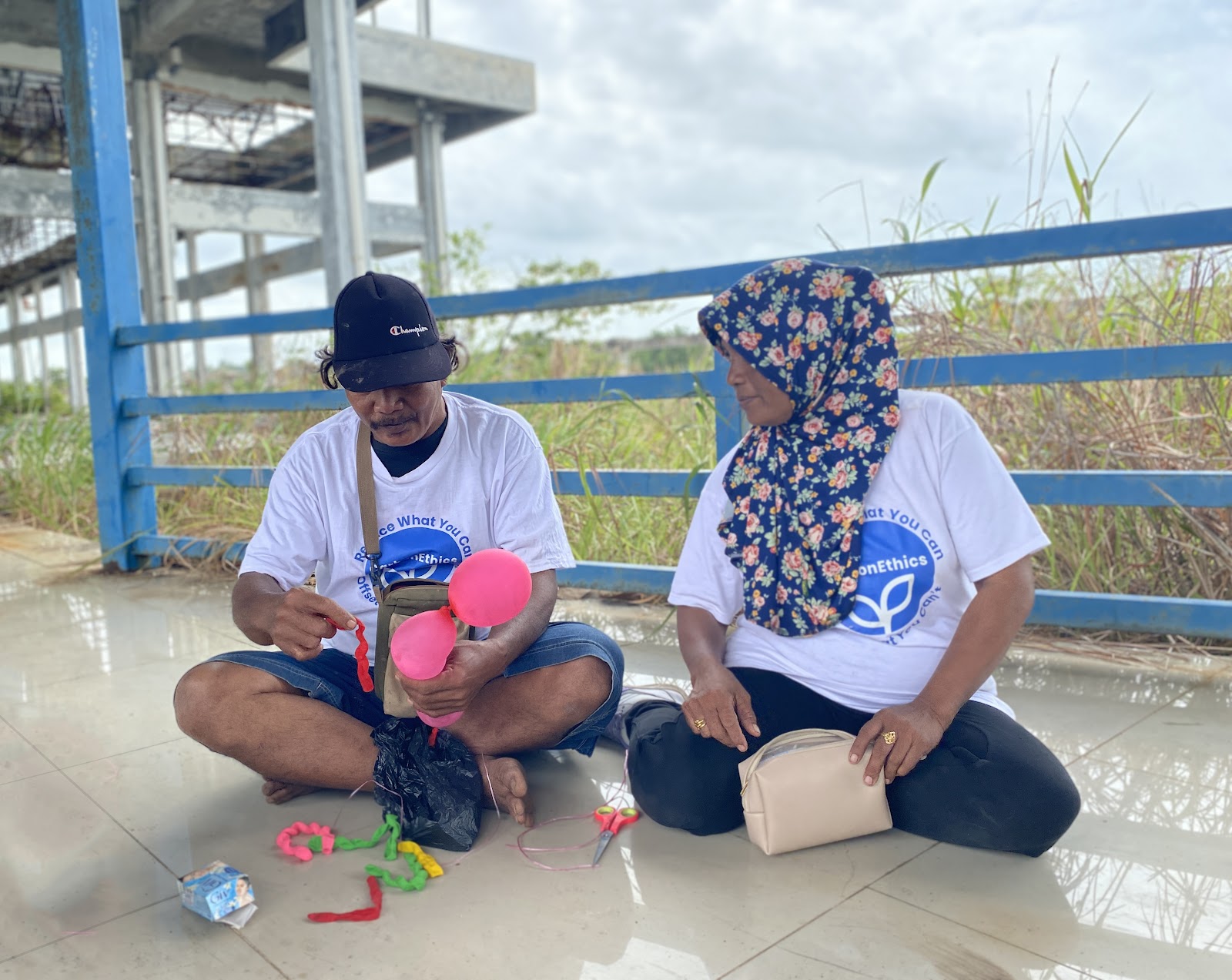 1 male and 1 female PPDL Farmers wearing white CarbonEthics shirt participating Egg Drop Game