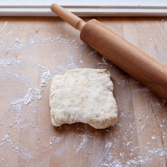 Chia khối bột thành hai phần bằng nhau. Rắc chút bột mì lên bàn cán bột, cho 1/2 phần bột ra. Dùng cán lăn, cán mỏng miếng bột thành hình chữ nhật và để bột nghỉ khoảng 5 phút rồi tiếp tục cán mỏng thêm lần nữa. Làm tương tự với phần bột còn lại.