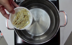 Cho khoảng 1 lít nước lạnh vào nồi, cho chổ gừng vừa cắt sợi vào nấu đến sôi.