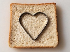 Đầu tiên, dùng khuôn cắt bánh ấn mạnh lên miếng bánh mì sandwich tạo thành 1 hình trái tim. Bơ cho vào nồi, nấu tan chảy.