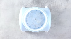 Chuẩn bị 1 cái tô lớn ở dưới cái máy làm đá bào. Cho đá viên vào khay. Dùng tay xoay tròn tay cầm để đá được xay mịn và rơi vào tô. Nếu các bạn không có máy làm đá bào thì có thể dùng máy sinh tố xay mịn đá hoặc mua sẵn đá bào mịn ở ngoài tiệm.