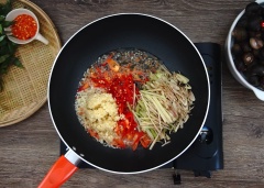 Đặt một chảo lớn lên trên bếp, làm nóng 4 muỗng canh dầu ăn. Cho tỏi ớt băm, ớt sừng thái lát, sả thái sợi vào chảo dầu xào thơm.