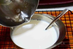 Tiếp đó cho 2 muỗng canh đường, 250ml sữa tươi vào nồi khuấy cho đến khi đường tan hoàn toàn. Đổ 1/2 phần gelatine vào chỗ sữa tươi rồi khấy đều.
