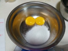 Cho 2 lòng đỏ trứng và 50g đường vào thố sâu lòng. Sử dụng máy đánh trứng đánh cho đến khi trứng dày và mịn.