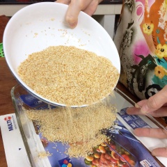 Bắc chảo lên bếp cho 400g đường và 1 chén nước vào nấu. Tranh thủ khi nấu đường, chế 1 muỗng canh dầu mè vào khuôn và rắc đều mè lên trên.