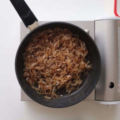 Đun nóng chảo đáy dày, cho khô cá vào rang khoảng 2 phút rồi cho ra tô để riêng. Đổ hỗn hợp vào chảo, đun to lửa cho sôi, đổ khô cá bò vào lại chảo. Thêm 1 muỗng canh dầu mè, đun và đảo đều cho khô ngấm đều sốt, rắc thêm ít mè trắng rang lên trên thì tắt bếp.