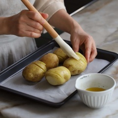 Cắt mỗi lát phô mai thành 6 miếng nhỏ. Phết bơ tan chảy lên các củ khoai, xếp xen kẽ phô mai vào các lát khoai, đem nướng ở 200 độ C trong 30 phút.