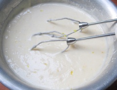 Cuối cùng, cho hỗn hợp sữa tươi không đường, lòng đỏ trứng, kem whipping, nước cốt chanh, vỏ chanh vào tô, dùng máy đánh trứng, đánh đều hỗn hợp thật mịn.